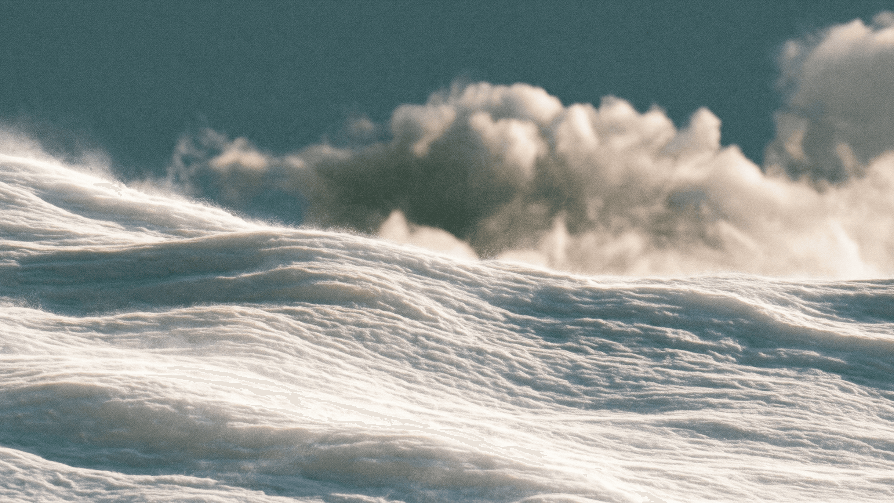 Wind-swept snow under drifting clouds