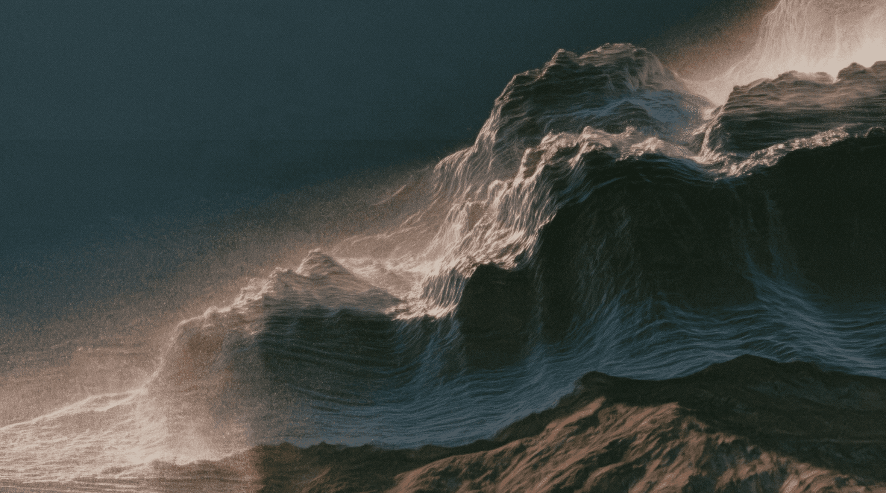 A dark ocean wave cresting over a rocky shore, its spray lit in warm backlight against a slate-blue sky.